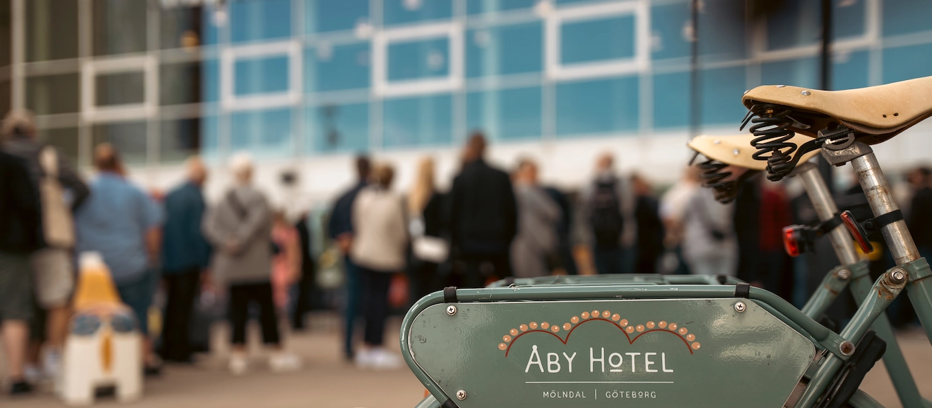 Blurry people in the background and Aby Hotel bicycle to rent