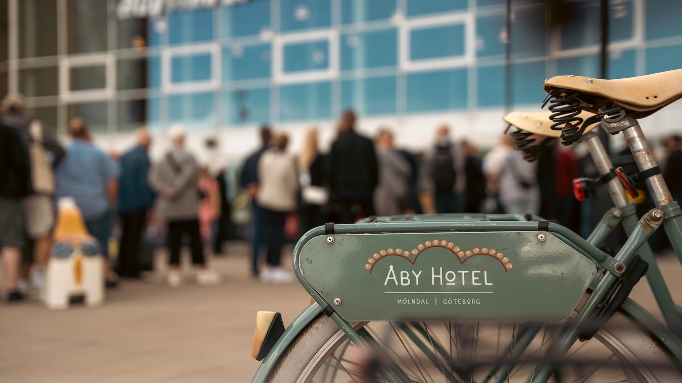Närbild på våra lånecyklar utanför Åby Arena och entré till hotellet
